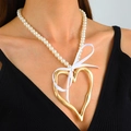 Collana di perle bianche con ciondolo a cuore dorato e fiocco indossata da modella - Cuore Oro (Catena di perle con fiocco bianco)