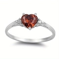 Detail shot of heart-cut red gemstone ring in silver setting with side stones - US 6 / Red