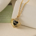 Detail of gold heart pendant with black enamel inlay and radiant sunburst rays - Black Cracked Heart Style / Black