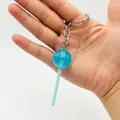 Close-up of a blue glow-in-the-dark lollipop keychain held in hand to show the scale - Blue