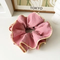 Oversized red and white plaid scrunchie with beige ruffle trim in an aesthetic setting - Oversized Red Plaid