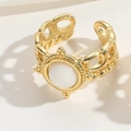 Detaillierte Makroansicht eines Goldrings mit weißem Edelstein und gewebter Textur - Weiß