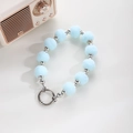Detail of light blue pompom and silver bead wristlet strap with metal spring clasp - Light Blue