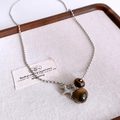 Detailed shot of tiger eye stone bead and silver terrier pendant on woven tray - 7# Silver-Coffee