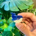 Blue and white whale resin hair claw clip held in hand against green leaf background - Dark Blue Dolphin