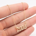 Close-up of golden stainless steel necklace with 2009 Old English font year pendant - 2009 / Gold