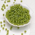 Translucent green 6mm round glass beads for DIY jewelry making displayed in a shell bowl - Olive Green Chalcedony Beads (6mm)