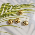 Makroaufnahme von facettierten Goldperlen für DIY-Schmuck auf grünem Blattgrund - 10mm / Normal vergoldet