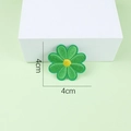 Close-up of green daisy embroidery patch with yellow core on light green background - Sunflower 1 / Green