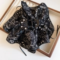 Detail of acrylic hair claw featuring black and white pattern with pearls and ribbons - Black Hair Claw