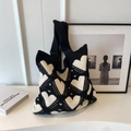 Knitted tote bag with black and white heart patterns shown in a stylish lifestyle setting - Black