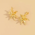 Macro shot of gold irregular floral earrings with polished metallic surface on beige - Flower Style