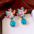 Dettaglio macro di orecchini d'oro vintage con farfalle in smalto e ciondolo gemma - Rosa Blu Placcato Oro Con Perno in Argento Sterling