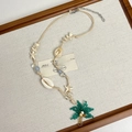 Détail d'un collier de perles bohème avec pendentif cocotier et coquillages naturels - Style J Cocotier & Étoile de Mer (Cordon Cire)