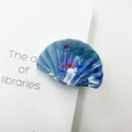 Blue marble texture shell hair claw clip with artistic patterns on a white book base - Jade Blue