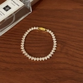 Detail of elegant gold bracelet featuring pear-cut cubic zirconia on a dark wood surface - Full Zircon Pear Shape