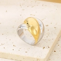 Detailopname van tweekleurige roestvrijstalen ring op een natuurlijke stenen voet - US 6 / Goud en Zilver