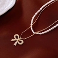 Detail of layered gold necklace with white pearls and sparkling rhinestone bow charm - 26# Gold Double Layer Bowknot Necklace