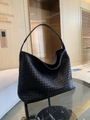 Handwoven black leather tote bag with Intrecciato pattern on a modern glass table - Black