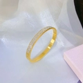 Dettaglio del bracciale in titanio dorato con tripla fila di cristalli su seta - Oro