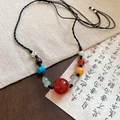 Dettaglio di perline etniche colorate e distanziatori in metallo inciso su corda intrecciata - Stile Giunzione Colore Agata Rossa (12# Collana-Nero-Rosso)