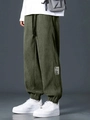 Detailed view of dark green corduroy joggers with drawstring waist and logo patch - S / Army Green