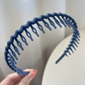 Matte navy blue wavy non-slip headband with comb teeth held by hand - Navy Blue