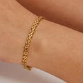 Bracelet cœur minimaliste en acier inoxydable plaqué or 18k porté sur un poignet féminin - Doré