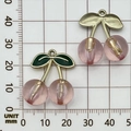 Translucent pink resin cherry pendant with green leaf charm on a metric scale grid - 1Pc Plated Transparent Pink Large Cherry (27x23mm)