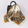Detail of paisley silk scarf in champagne hue draped over a textured black leather handbag - D9239-Creamy White