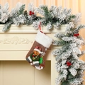 Detalle de calcetín de Navidad de felpa marrón con oso 3D y adornos festivos - Oso