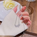 Elegant silver titanium necklace with three floral crystal pendants held by a hand - X684 Silver Snowflake Flower