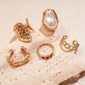 Detail von 5-teiligem goldenem geometrischem Ring-Set mit Perle und Strass auf Stein - Gold