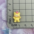 Macro view of a 2cm yellow resin bear figurine with apple and ruler for scale - Yellow Apple Bear
