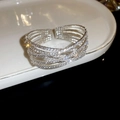 Close-up of sparkling multilayer rhinestone bracelet on white ceramic display tray - 3# 6-Layer Silver Cross Bangle