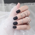 Short square-oval matte black press-on nails shown on hand with silver rings decor - Matte Matte Black (DFYM-01)
