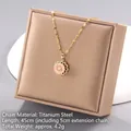 Gold titanium necklace with pink daisy pendant and central pearl on a gift box - Pink Daisy Style (Rotating No. 94 A1399)