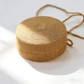 Gros plan d'un sac bandoulière rond en paille avec texture tissée en spirale et sangle - Petit Sac Rond / 12*6.5cm / Kaki