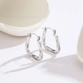 Minimalist silver irregular geometric titanium steel hoop earrings on white display - Steel Color Twisted Geometric