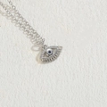 Silver Evil Eye necklace with blue stone and white zircon on white textured background - Eyelash Eye Platinum Plated (XL2372)