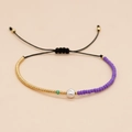 Dettaglio del bracciale dell'amicizia con perle viola, perla barocca e cordino nero regolabile - Corda Nera Perline Viola Oro Perla Artificiale