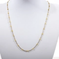 Detail of a thin gold beaded necklace with yellow enamel beads on a white neck display - Gold + Yellow
