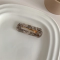 French vintage marble acetate hair clip on a white ceramic plate with a golden metal base - Grey Marble Square