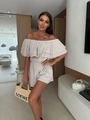 Detail van de ruches off-shoulder halslijn en getextureerde stof van de beige romper - S / Abrikoos