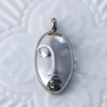 Silver vintage face mask pendant in polished stainless steel with detailed metallic luster - Abstract Face / Steel