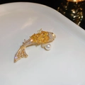 Dettaglio di una spilla a forma di carpa koi dorata con zirconi gialli e una perla bianca - Spilla Pesce Koi Fortunato Dorata