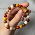Detailed view of handmade Buddhist wood bead bracelet with engraved cylinder charm and gold spacers - Bamboo Style