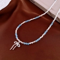 Detailopname van blauwe facetkralen en zilveren strikhanger op een zijden ondergrond - 18# Ketting-Blauwe Strik Hanger
