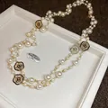 Detail der Vintage-Perlenkette mit goldenen Kamelienanhängern und schwarzer Emaille - Goldener Kamelien-Anhänger Mehrlagiger Stil / Gold-Weiß