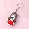 Cute cartoon dog keychain with red overalls on a pink decorative display tray - Basset Hound
